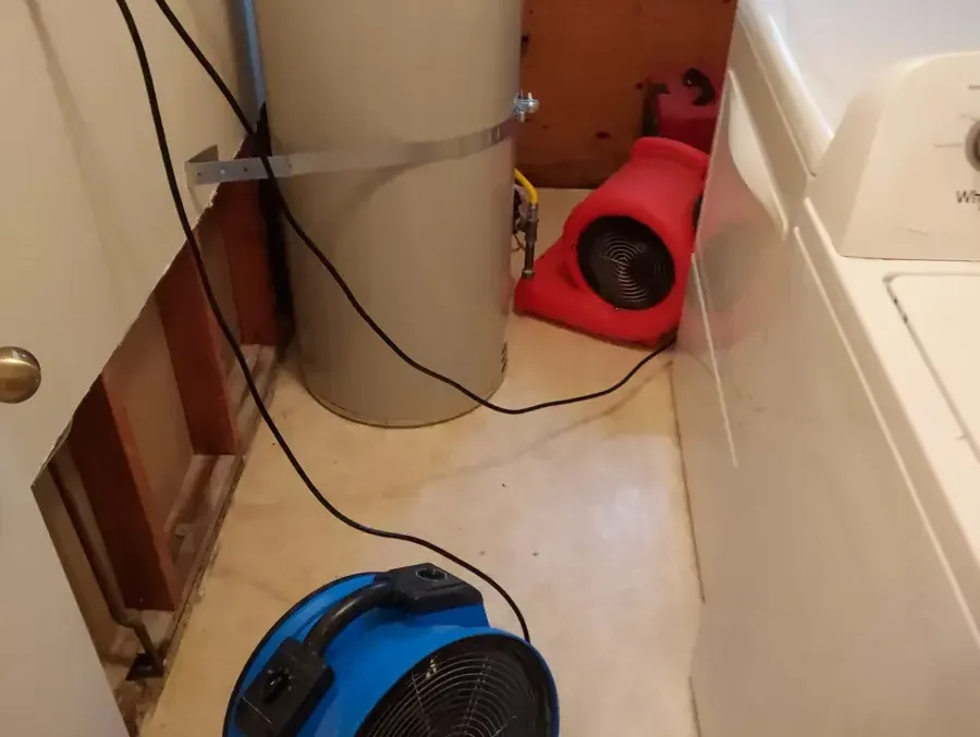 Air movers drying a laundry area with the wall opened behind the washer