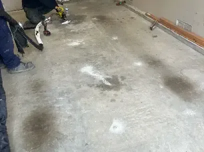Flooring pulled up to expose a wet concrete slab after a slab leak